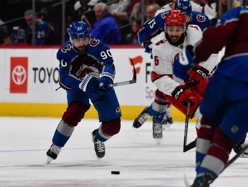 Oct 21, 2023; Denver, Colorado, USA;  Colorado Avalanche left wing Tomas Tatar (90) and Carolina Hurricanes defenseman Jalen Chatfield (5) chase after the puck in the first period at Ball Arena. Mandatory Credit: John Leyba-USA TODAY Sports