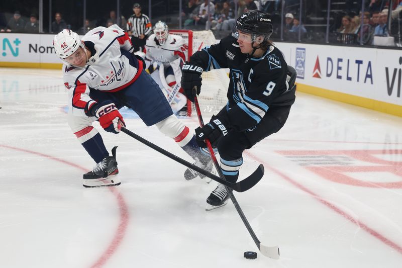 Mar 26, 2026; Salt Lake City, Utah, USA; Utah Mammoth right wing Clayton Keller (9) makes a pass against Washington Capitals defenseman Martin Fehérváry (42) during the third period at Delta Center. Mandatory Credit: Rob Gray-Imagn Images