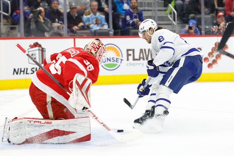 Dec 14, 2024; Detroit, Michigan, USA;  Detroit Red Wings goaltender Ville Husso (35) makes a save on Toronto Maple Leafs defenseman Chris Tanev (8) in the first period at Little Caesars Arena. Mandatory Credit: Rick Osentoski-Imagn Images