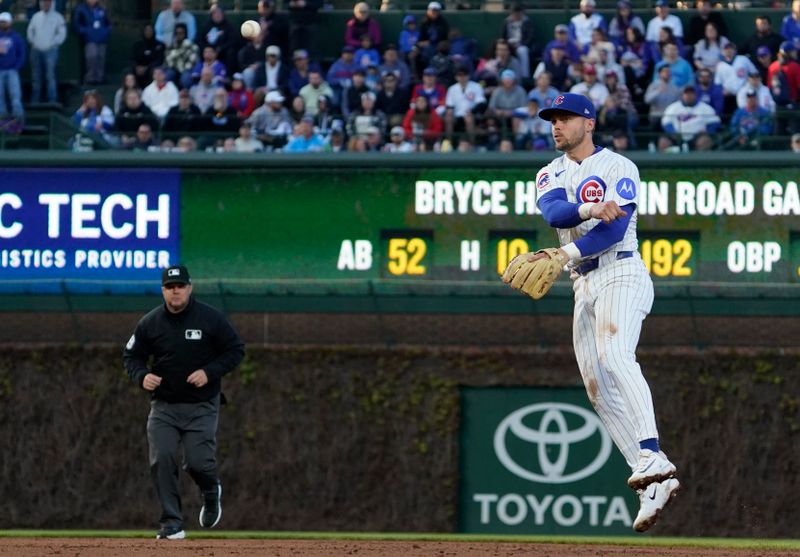 Apr 27, 2025; Chicago, Illinois, USA; Chicago Cubs second base Nico Hoerner (2) makes a play on Philadelphia Phillies first base Bryce Harper (3) during the third inning at Wrigley Field. Mandatory Credit: David Banks-Imagn Images