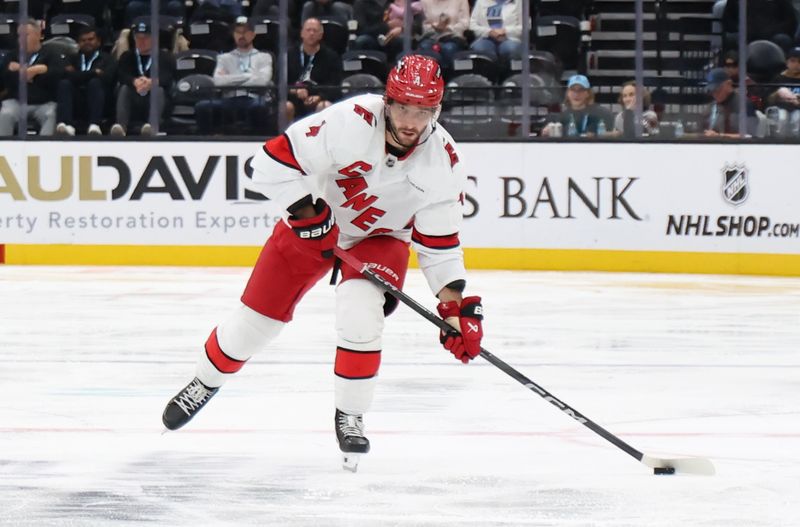 Nov 13, 2024; Salt Lake City, Utah, USA; Carolina Hurricanes defenseman Shayne Gostisbehere (4) clears the puck against the Utah Hockey Club during the third period at Delta Center. Mandatory Credit: Rob Gray-Imagn Images