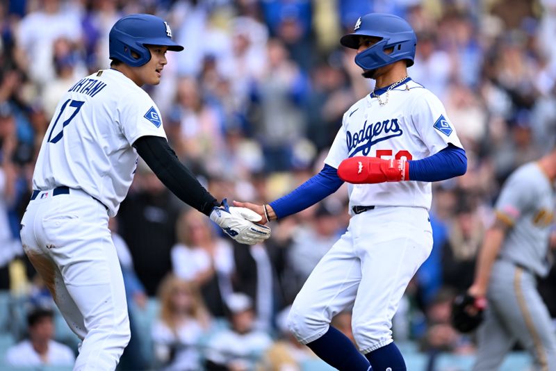 Apr 27, 2025; Los Angeles, California, USA; Los Angeles Dodgers designated hitter Shohei Ohtani (17) celebrates with shortstop Mookie Betts (50) after they scored during the first inning against the Pittsburgh Pirates at Dodger Stadium. Mandatory Credit: Jonathan Hui-Imagn Images