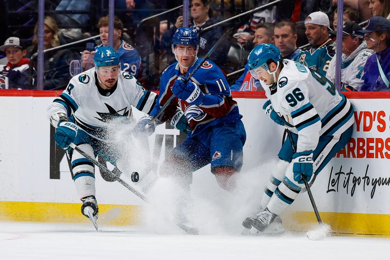 Feb 4, 2026; Denver, Colorado, USA; Colorado Avalanche center Brock Nelson (11) battles for the puck with San Jose Sharks defenseman Dmitry Orlov (9) and center Philipp Kurashev (96) in the first period at Ball Arena. Mandatory Credit: Isaiah J. Downing-Imagn Images