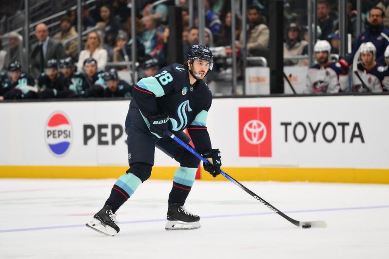 Nov 12, 2024; Seattle, Washington, USA; Seattle Kraken defenseman Joshua Mahura (28) plays the puck during the third period against the Columbus Blue Jackets at Climate Pledge Arena. Mandatory Credit: Steven Bisig-Imagn Images