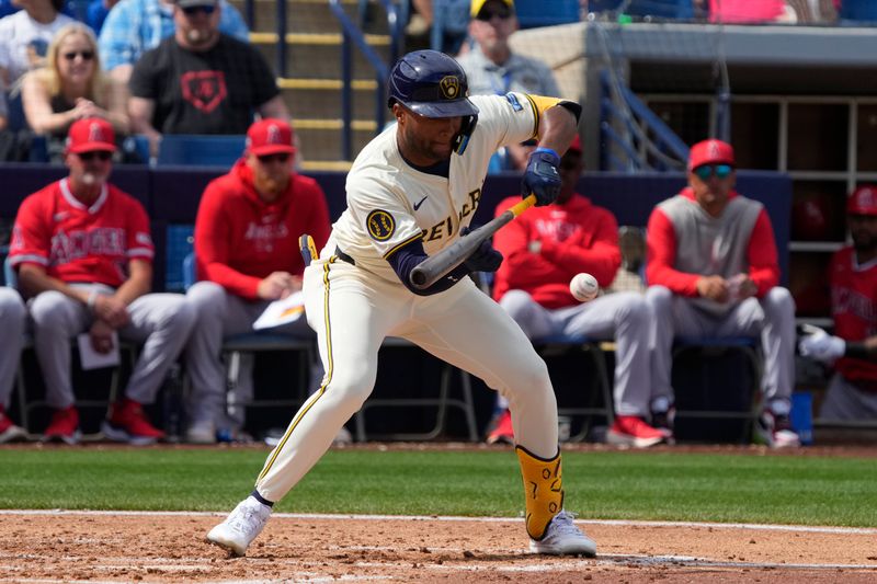 Mar 18, 2024; Phoenix, Arizona, USA; Milwaukee Brewers right fielder Jackson Chourio (11) bunts for a single against the Los Angeles Angels in the second inning at American Family Fields of Phoenix. Mandatory Credit: Rick Scuteri-USA TODAY Sports