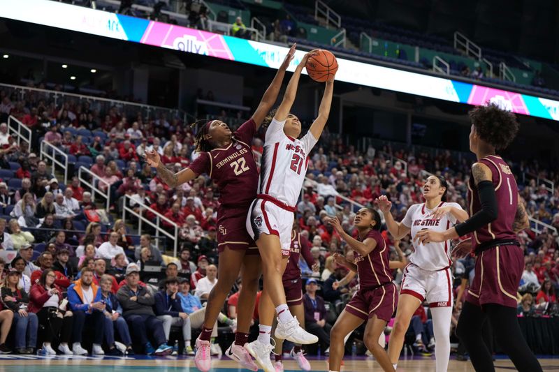 Mar 9, 2024; Greensboro, NC, USA; NC State Wolfpack guard Madison Hayes (21) gets a rebound from Florida State Seminoles forward Sakyia White (22) in the first half at Greensboro Coliseum. Mandatory Credit: David Yeazell-USA TODAY Sports