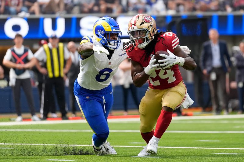 San Francisco 49ers running back Jordan Mason (24) runs against Los Angeles Rams linebacker Jared Verse during the first half of an NFL football game, Sunday, Sept. 22, 2024, in Inglewood, Calif. (AP Photo/Ashley Landis)