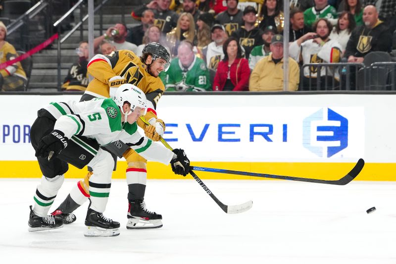 Dec 6, 2024; Las Vegas, Nevada, USA; Vegas Golden Knights center Brett Howden (21) shoots against the stick of Dallas Stars defenseman Nils Lundkvist (5) during the second period at T-Mobile Arena. Mandatory Credit: Stephen R. Sylvanie-Imagn Images