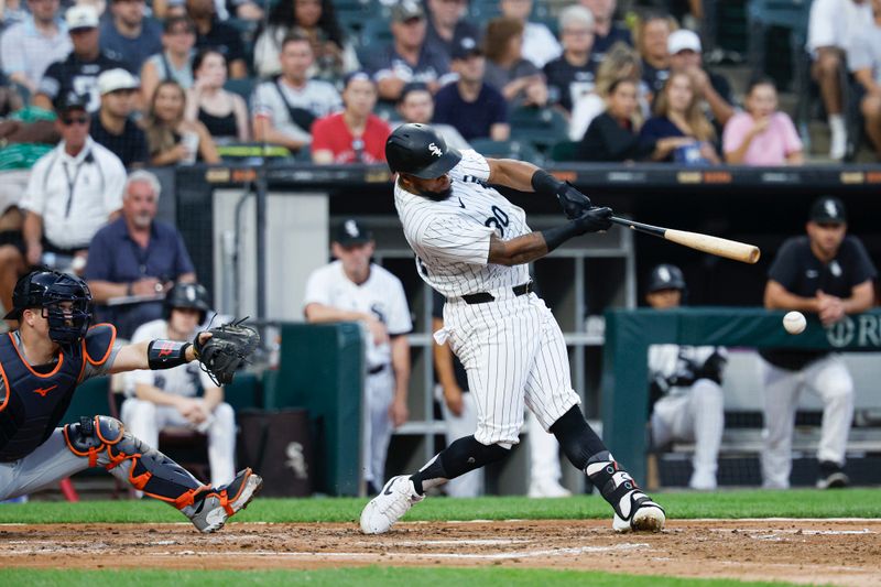 Aug 24, 2024; Chicago, Illinois, USA; Chicago White Sox outfielder Corey Julks (30) hits an RBI-single against the Detroit Tigers during the third inning at Guaranteed Rate Field. Mandatory Credit: Kamil Krzaczynski-USA TODAY Sports