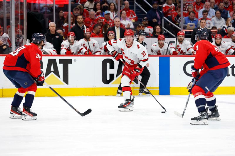 May 6, 2025; Washington, District of Columbia, USA; Carolina Hurricanes right wing Andrei Svechnikov (37) skates with the puck as Washington Capitals defenseman Rasmus Sandin (38) as Capitals defenseman Matt Roy (3) defend in the second period in game one of the second round of the 2025 Stanley Cup Playoffs at Capital One Arena. Mandatory Credit: Geoff Burke-Imagn Images