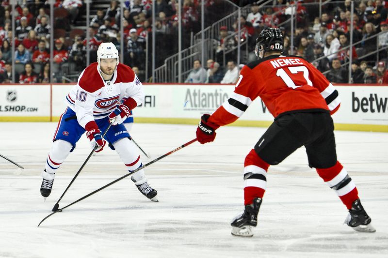 Feb 24, 2024; Newark, New Jersey, USA; Montreal Canadiens right wing Joel Armia (40) skates with the puck while being defended by New Jersey Devils defenseman Simon Nemec (17) during the first period at Prudential Center. Mandatory Credit: John Jones-USA TODAY Sports