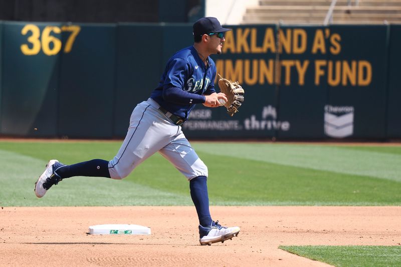 Sep 20, 2023; Oakland, California, USA; Seattle Mariners second baseman Josh Rojas (4) gathers the ball against the Oakland Athletics during the fourth inning at Oakland-Alameda County Coliseum. Mandatory Credit: Kelley L Cox-USA TODAY Sports