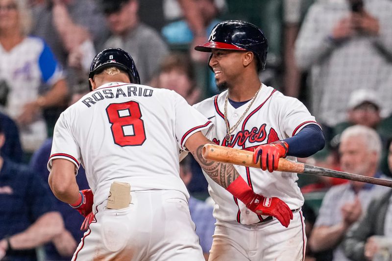 Apr 12, 2023; Cumberland, Georgia, USA; Atlanta Braves left fielder Eddie Rosario (8) reacts with second baseman Ozzie Albies (1) after hitting a home run against the Cincinnati Reds during the eighth inning at Truist Park. Mandatory Credit: Dale Zanine-USA TODAY Sports