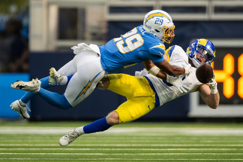 Los Angeles Rams wide receiver Drake Stoops, bottom, bobbles the ball as Los Angeles Chargers cornerback Tarheeb Still dives during an NFL preseason football game, Saturday, Aug. 17, 2024, in Inglewood, Calif. (AP Photo/Kyusung Gong)