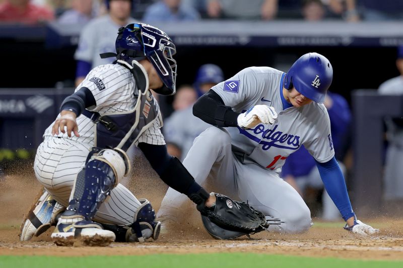 Jun 9, 2024; Bronx, New York, USA; Los Angeles Dodgers designated hitter Shohei Ohtani (17) scores ahead of the tag by New York Yankees catcher Jose Trevino (39) on a sacrifice fly by Dodgers catcher Will Smith (not pictured) during the eighth inning at Yankee Stadium. Mandatory Credit: Brad Penner-USA TODAY Sports