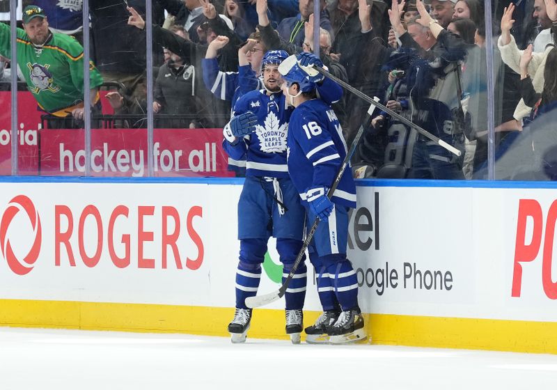 Mar 6, 2024; Toronto, Ontario, CAN; Toronto Maple Leafs center Auston Matthews (34) scores the winning goal and celebrates with Toronto Maple Leafs right wing Mitchell Marner (16) against the Buffalo Sabres during the overtime period at Scotiabank Arena. Mandatory Credit: Nick Turchiaro-USA TODAY Sports