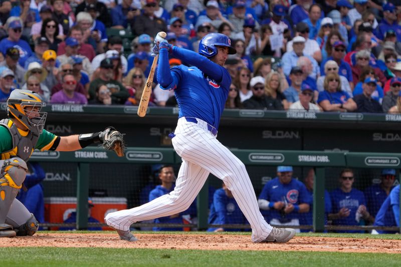 Mar 14, 2024; Mesa, Arizona, USA; Chicago Cubs center fielder Cody Bellinger (24) hits a single against the Oakland Athletics in the fourth inning at Sloan Park. Mandatory Credit: Rick Scuteri-USA TODAY Sports