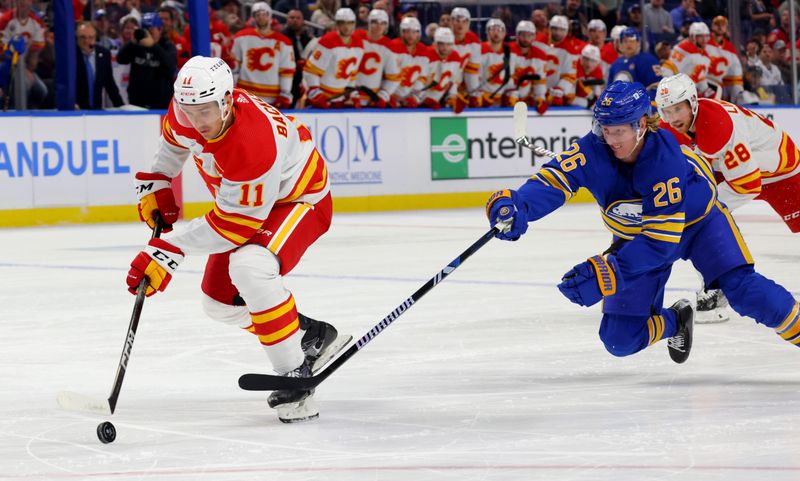 Oct 19, 2023; Buffalo, New York, USA;  Buffalo Sabres defenseman Rasmus Dahlin (26) dives to try and knock the puck off the stick of Calgary Flames center Mikael Backlund (11) during the first period at KeyBank Center. Mandatory Credit: Timothy T. Ludwig-USA TODAY Sports