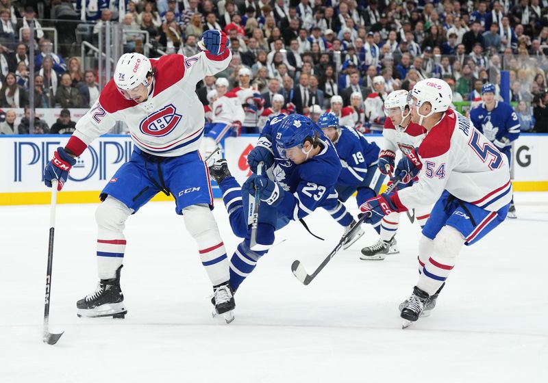 Oct 11, 2023; Toronto, Ontario, CAN; Toronto Maple Leafs left wing Matthew Knies (23) battles for the puck between Montreal Canadiens defenseman Arber Xhekaj (72) and defenseman Jordan Harris (54) during the third period at Scotiabank Arena. Mandatory Credit: Nick Turchiaro-USA TODAY Sports