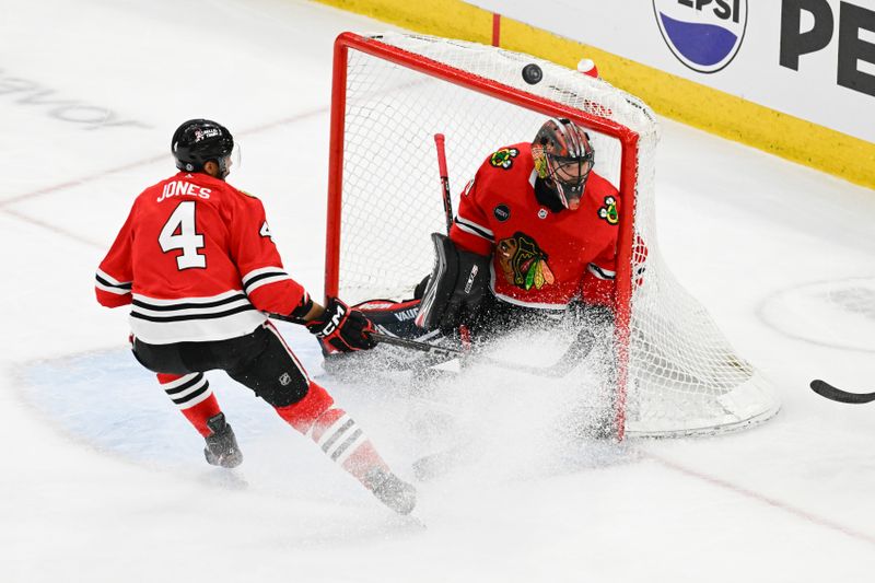 Apr 7, 2024; Chicago, Illinois, USA;  Chicago Blackhawks goaltender Arvid Soderblom (40) and defenseman Seth Jones (4) looks on as a puck flies by against the Minnesota Wild during the first period at the United Center. Mandatory Credit: Matt Marton-USA TODAY Sports