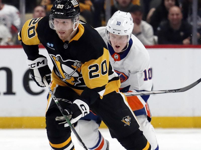 Feb 20, 2024; Pittsburgh, Pennsylvania, USA; Pittsburgh Penguins center Lars Eller (20) moves the puck up ice ahead of New York Islanders right wing Simon Holmstrom (10) during the third period at PPG Paints Arena. New York won 5-4 in overtime. Mandatory Credit: Charles LeClaire-USA TODAY Sports