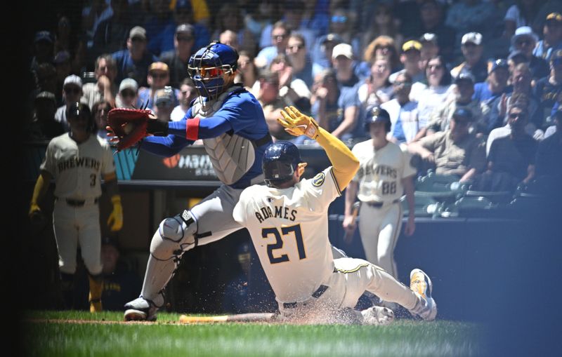 May 30, 2024; Milwaukee, Wisconsin, USA; Milwaukee Brewers shortstop Willy Adames (27) slides in safely to home plate against Chicago Cubs catcher Miguel Amaya (9) in the second inning at American Family Field. Mandatory Credit: Michael McLoone-USA TODAY Sports