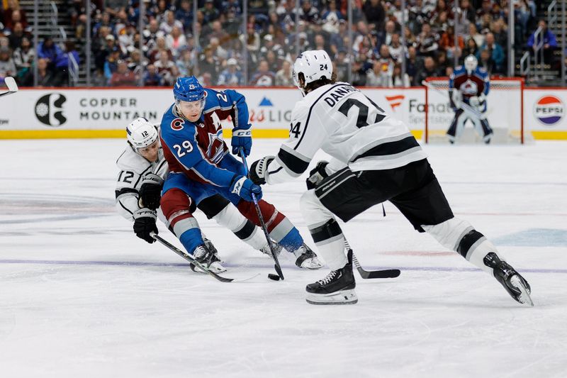 Jan 26, 2024; Denver, Colorado, USA; Colorado Avalanche center Nathan MacKinnon (29) controls the puck against Los Angeles Kings left wing Trevor Moore (12) and center Phillip Danault (24) in the second period at Ball Arena. Mandatory Credit: Isaiah J. Downing-USA TODAY Sports