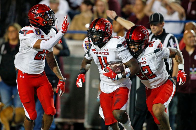 Dec 28, 2021; Memphis, TN, USA; Texas Tech Red Raiders defensive back Dadrion Taylor-Demerson (left) and defensive back Reggie Pearson Jr. (right) celebrate with defensive back Eric Monroe (center) after an interception during the second half against the Mississippi State Bulldogs at Liberty Bowl Stadium. Mandatory Credit: Petre Thomas-USA TODAY Sports