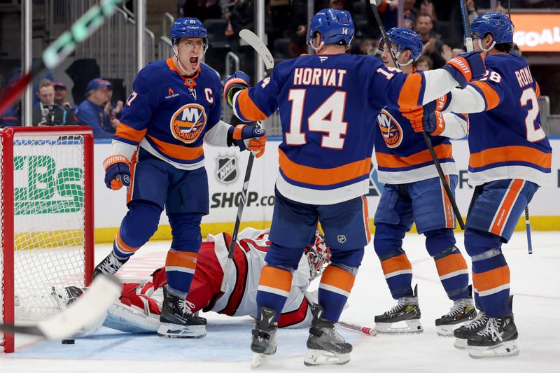 Jan 25, 2025; Elmont, New York, USA; New York Islanders left wing Anders Lee (27) celebrates his game tying goal against Carolina Hurricanes goaltender Pyotr Kochetkov (52) with Islanders center Bo Horvat (14) and defenseman Alexander Romanov (28) during the third period at UBS Arena. Mandatory Credit: Brad Penner-Imagn Images