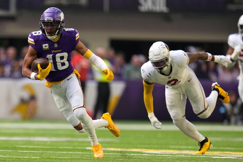 Minnesota Vikings wide receiver Justin Jefferson (18) runs from Arizona Cardinals linebacker Mack Wilson Sr. (2) after catching a pass during the first half of an NFL football game Sunday, Dec. 1, 2024, in Minneapolis. (AP Photo/Abbie Parr)