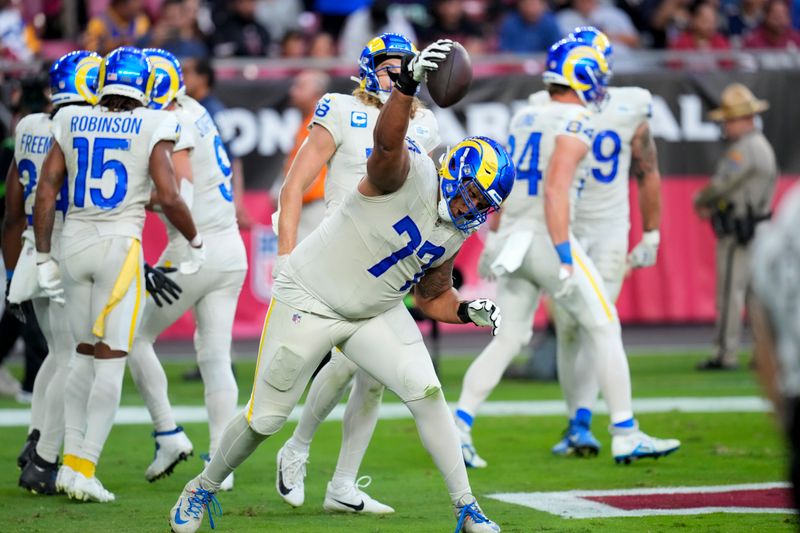 Los Angeles Rams offensive tackle Alaric Jackson spikes the ball after a touchdown by teammate running back Royce Freeman during the second half of an NFL football game against the Arizona Cardinals, Sunday, Nov. 26, 2023, in Glendale, Ariz. (AP Photo/Ross D. Franklin)