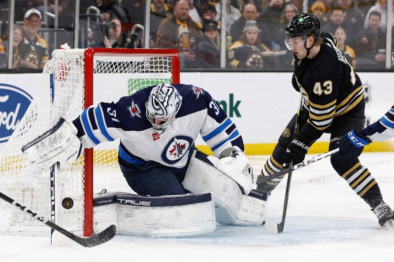 Jan 22, 2024; Boston, Massachusetts, USA; Winnipeg Jets goaltender Connor Hellebuyck (37) tries to coral a loose puck as Boston Bruins left wing Danton Heinen (43) waits in front during the second period at TD Garden. Mandatory Credit: Winslow Townson-USA TODAY Sports