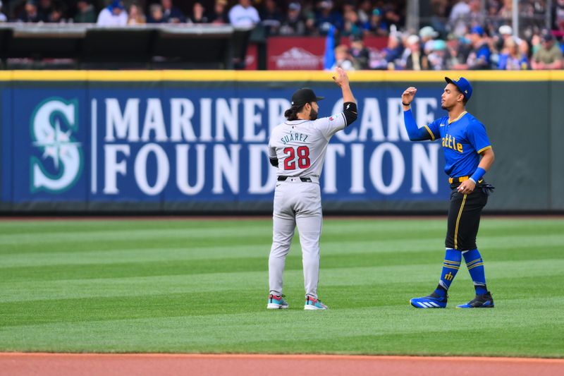 Apr 26, 2024; Seattle, Washington, USA; Arizona Diamondbacks third baseman Eugenio Suarez (28) and Seattle Mariners center fielder Julio Rodriguez (44) greet each other prior to the game at T-Mobile Park. Mandatory Credit: Steven Bisig-USA TODAY Sports