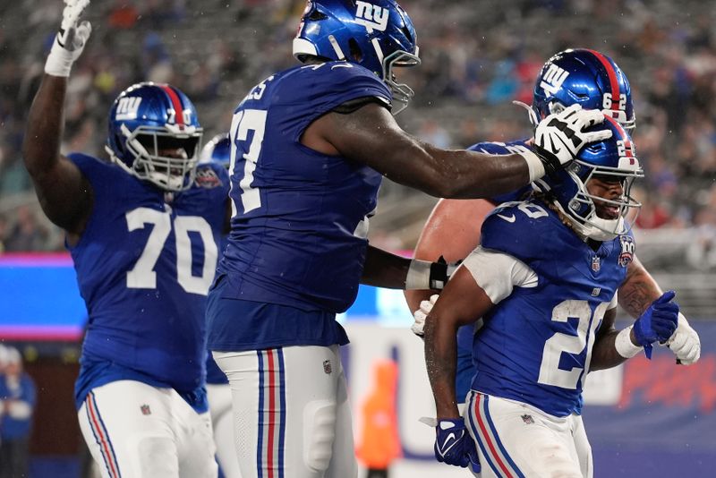 New York Giants running back Eric Gray (20) is congratulated by teammates after scoring a touchdown against the Detroit Lions during the second quarter of an NFL football game, Thursday, Aug. 8, 2024, in East Rutherford, N.J. (AP Photo/Seth Wenig)