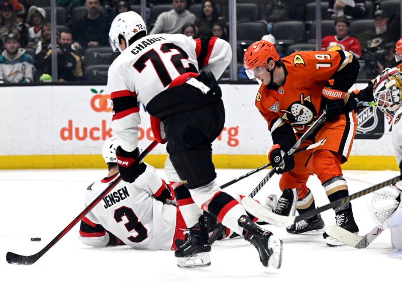 Dec 1, 2024; Anaheim, California, USA;  Anaheim Ducks right wing Troy Terry (19) gets blocked by Ottawa Senators defenseman Nick Jensen (3), as defenseman Thomas Chabot (72) vies for the puck at Honda Center. Mandatory Credit: Alex Gallardo-Imagn Images