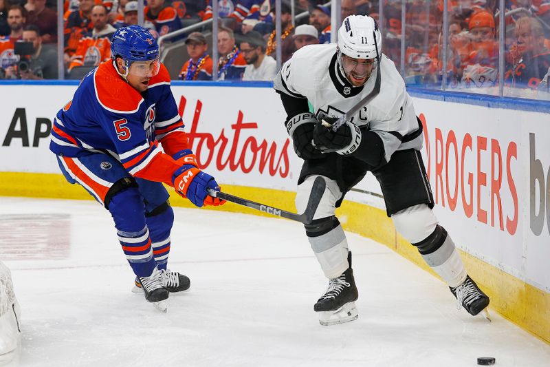 Apr 22, 2024; Edmonton, Alberta, CAN; Edmonton Oilers defensemen Cody Ceci (5) and Los Angeles Kings forward Anze Kopitar (11) battle along the boards for a loose puck  during the second period in game one of the first round of the 2024 Stanley Cup Playoffs at Rogers Place. Mandatory Credit: Perry Nelson-USA TODAY Sports