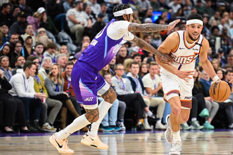 SALT LAKE CITY, UTAH - DECEMBER 13: Devin Booker #1 of the Phoenix Suns drives into Jordan Clarkson #00 of the Utah Jazz during the second half of a game at Delta Center on December 13, 2024 in Salt Lake City, Utah.  NOTE TO USER: User expressly acknowledges and agrees that, by downloading and or using this photograph, User is consenting to the terms and conditions of the Getty Images License Agreement. (Photo by Alex Goodlett/Getty Images)