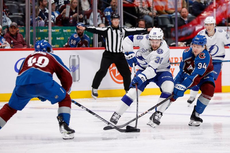 Oct 30, 2024; Denver, Colorado, USA; Tampa Bay Lightning left wing Brandon Hagel (38) battles for the puck with Colorado Avalanche left wing Joel Kiviranta (94) and defenseman Samuel Girard (49) in the third period at Ball Arena. Mandatory Credit: Isaiah J. Downing-Imagn Images