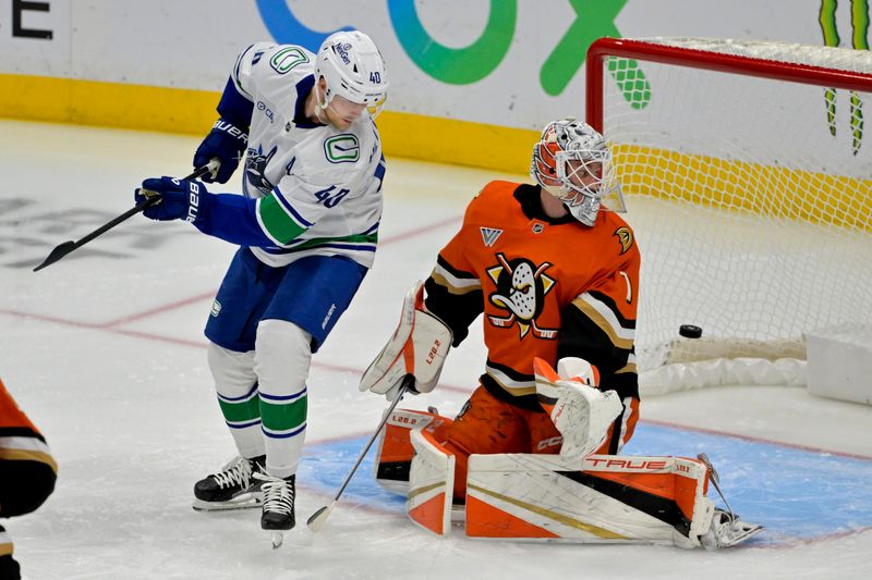 Nov 5, 2024; Anaheim, California, USA; The puck flies past Vancouver Canucks center Elias Pettersson (40) and Anaheim Ducks goaltender Lukas Dostal (1) for a score by Vancouver Canucks defenseman Quinn Hughes (43) in the second period shot by  at Honda Center. Mandatory Credit: Jayne Kamin-Oncea-Imagn Images