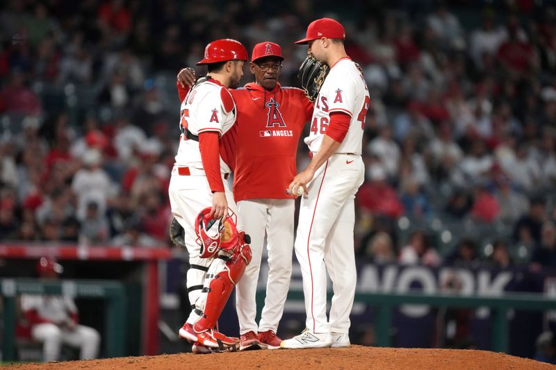 May 28, 2025; Anaheim, California, USA; Los Angeles Angels manager Ron Washington (center) talks with catcher Travis d'Arnaud (25) and relief pitcher Reid Detmers (48) in the eighth inning against the Los Angeles Angels at Angel Stadium. Mandatory Credit: Kirby Lee-Imagn Images