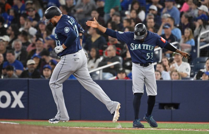 Apr 20, 2025; Toronto, Ontario, CAN;  Seattle Mariners first baseman Rowdy Tellez (23) runs past first base coach Eric Young Jr. (53) after hitting a two run home run against the Toronto Blue Jays in the seventh inning at Rogers Centre. Mandatory Credit: Dan Hamilton-Imagn Images