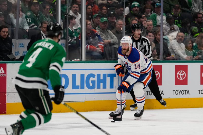 Feb 17, 2024; Dallas, Texas, USA; Edmonton Oilers defenseman Mattias Ekholm (14) skates with the puck against Dallas Stars defenseman Miro Heiskanen (4) during the first period at American Airlines Center. Mandatory Credit: Chris Jones-USA TODAY Sports