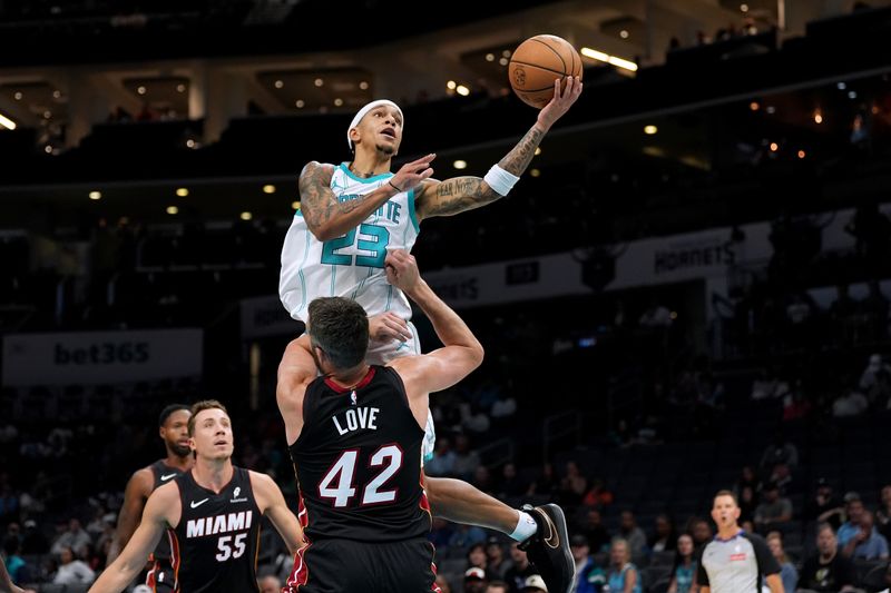 CHARLOTTE, NORTH CAROLINA - OCTOBER 08: Tre Mann #23 of the Charlotte Hornets goes to the basket against Kevin Love #42 of the Miami Heat during the first half of the preseason game at Spectrum Center on October 08, 2024 in Charlotte, North Carolina. NOTE TO USER: User expressly acknowledges and agrees that, by downloading and or using this photograph, User is consenting to the terms and conditions of the Getty Images License Agreement. (Photo by Grant Halverson/Getty Images)