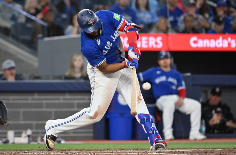 May 21, 2025; Toronto, Ontario, CAN;  Toronto Blue Jays first baseman Vladimir Guerrero Jr. (27) hits a RBI single against the San Diego Padres in the seventh inning at Rogers Centre. Mandatory Credit: Dan Hamilton-Imagn Images