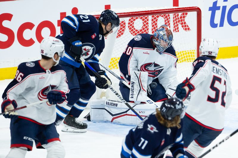 Jan 9, 2024; Winnipeg, Manitoba, CAN; Columbus Blue Jackets goalie Daniil Tarasov (40) makes a save as Winnipeg Jets forward Dominic Toninato (21) looks for a rebound during the third period at Canada Life Centre. Mandatory Credit: Terrence Lee-USA TODAY Sports