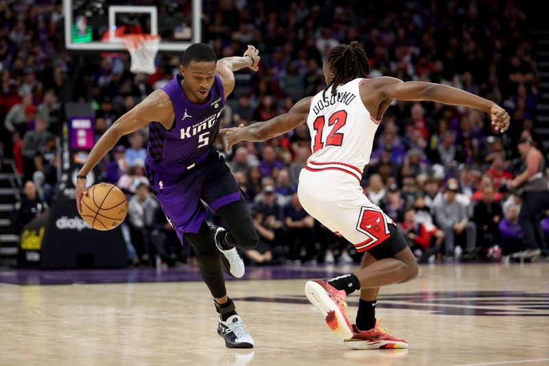 SACRAMENTO, CALIFORNIA - MARCH 04: De'Aaron Fox #5 of the Sacramento Kings is guarded by Ayo Dosunmu #12 of the Chicago Bulls in the second half at Golden 1 Center on March 04, 2024 in Sacramento, California. NOTE TO USER: User expressly acknowledges and agrees that, by downloading and or using this photograph, User is consenting to the terms and conditions of the Getty Images License Agreement.  (Photo by Ezra Shaw/Getty Images)