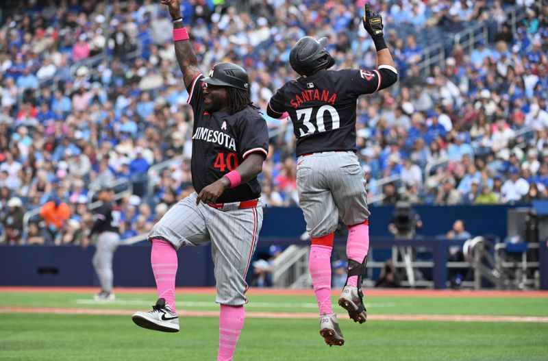 May 12, 2024; Toronto, Ontario, CAN;  Minnesota Twins first baseman Carlos Santana (30) celebrates with third base coach Tommy Watkins (40) after hitting a three run home run against the Toronto Blue Jays in the seventh inning at Rogers Centre. Mandatory Credit: Dan Hamilton-USA TODAY Sports