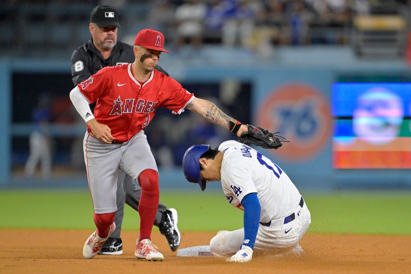 Jun 21, 2024; Los Angeles, California, USA;  Los Angeles Dodgers designated hitter Shohei Ohtani (17) is tagged out by Los Angeles Angels shortstop Zach Neto (9) on an attempted stolen base in the eighth inning at Dodger Stadium. Mandatory Credit: Jayne Kamin-Oncea-USA TODAY Sports