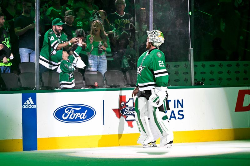 May 25, 2024; Dallas, Texas, USA;Dallas Stars goaltender Jake Oettinger (29) throws a puck to a fan after the Dallas Stars defeat the Edmonton Oilers in game two of the Western Conference Final of the 2024 Stanley Cup Playoffs at American Airlines Center. Mandatory Credit: Jerome Miron-USA TODAY Sports