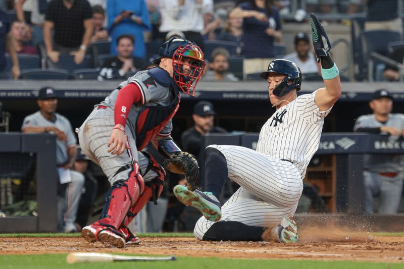 Jun 6, 2024; Bronx, New York, USA; New York Yankees center fielder Aaron Judge (99) beats the throw to score a run behind Minnesota Twins catcher Christian Vazquez (8) during the third inning at Yankee Stadium. Mandatory Credit: Vincent Carchietta-USA TODAY Sports